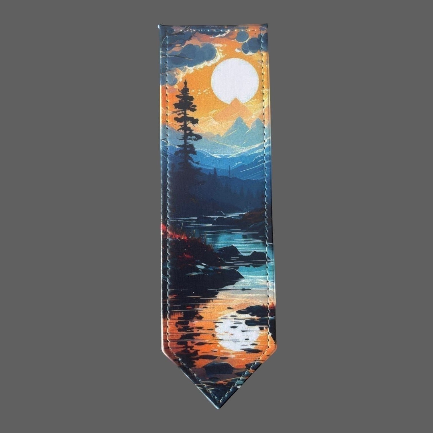 Illustrated Solutions Store leather bookmark featuring a mountain sunrise reflection over water, with a pine tree silhouette.