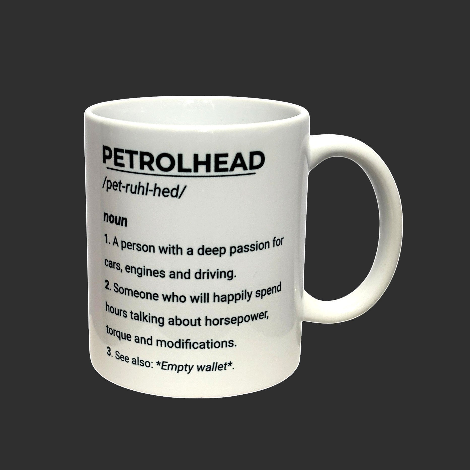 Illustrated Solutions Store white ceramic mug with black text defining 'PETROLHEAD' as a noun with three points, ideal for car enthusiasts.