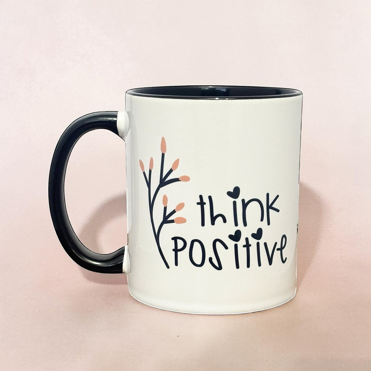 Affirmation mug with "think POSITIVE" text and floral design, black handle and rim.