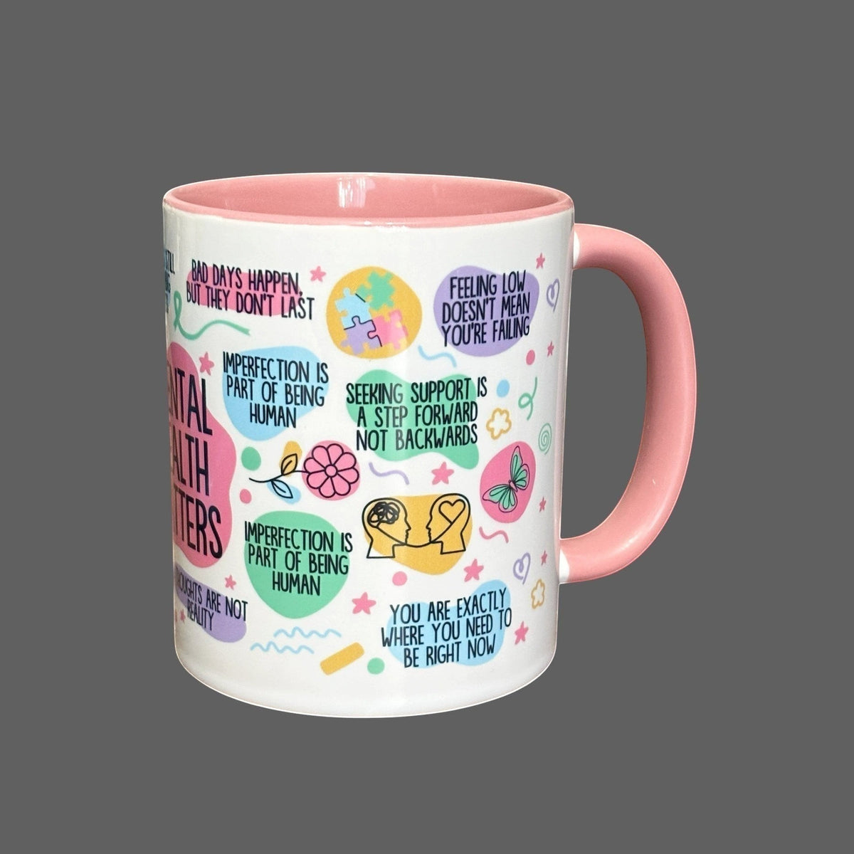 white ceramic mug with pink handle and interior, featuring mental health awareness designs and uplifting messages.