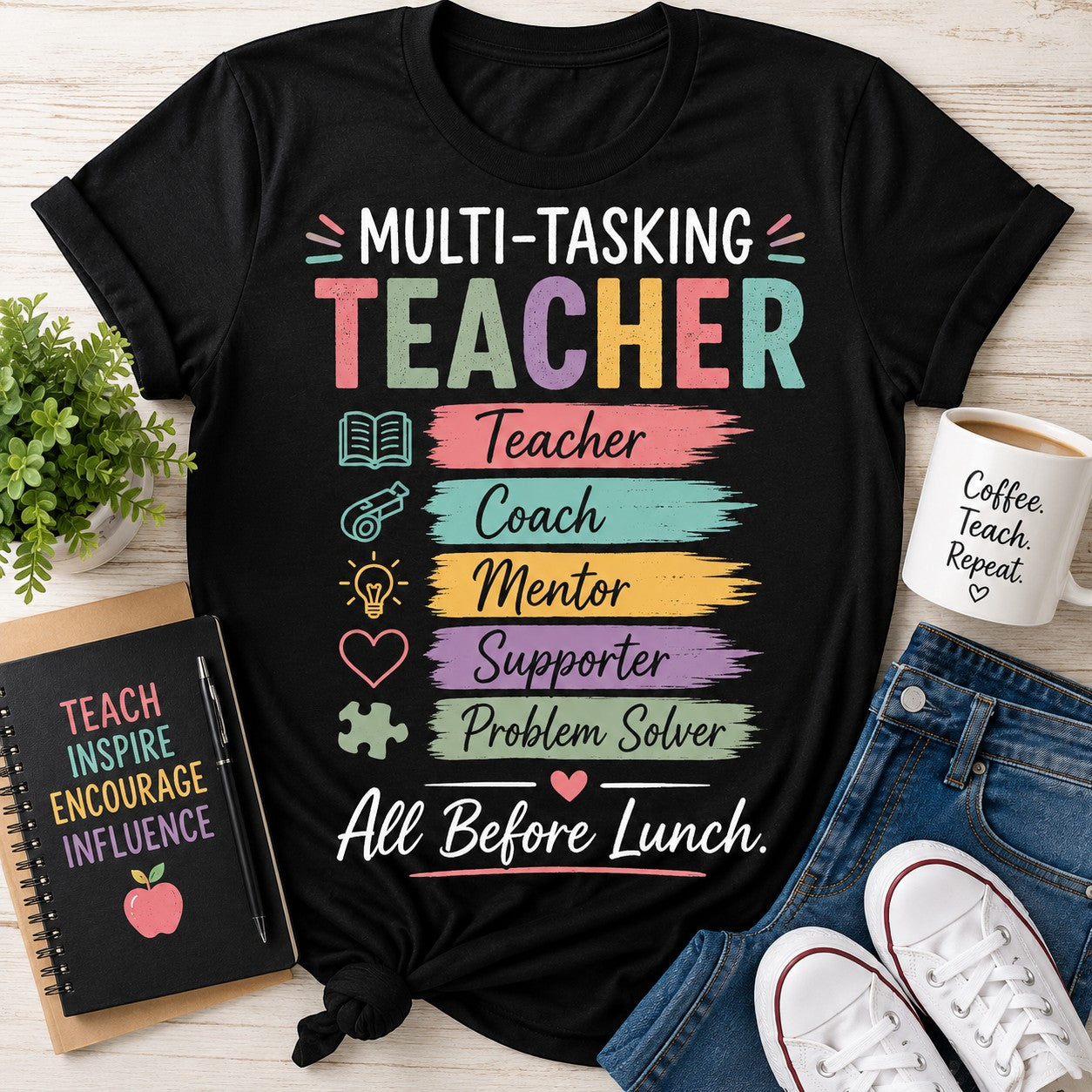 Black t-shirt with colorful text 'Multi-Tasking Teacher' on a wooden surface with accessories.