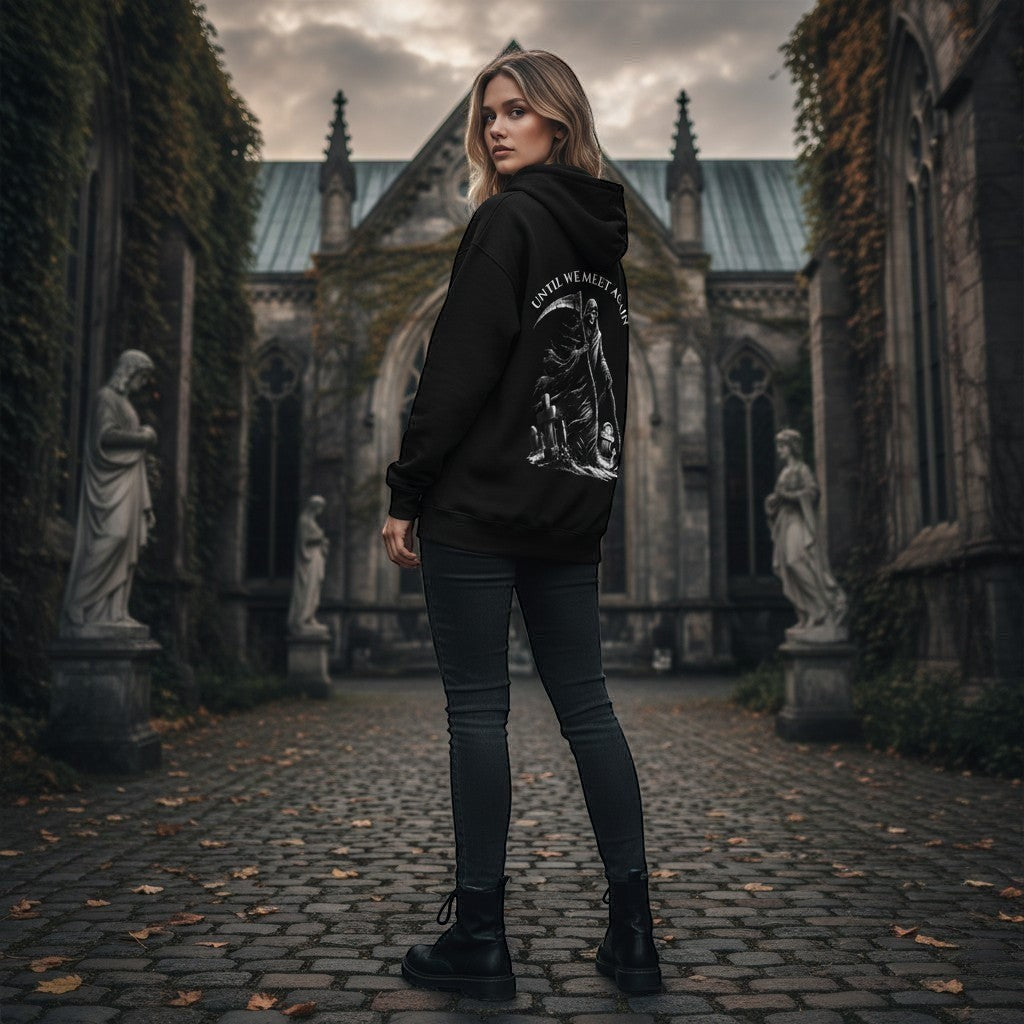 black gothic hoodie with a grim reaper graphic and "Until We Meet Again" text stood outside a church.
