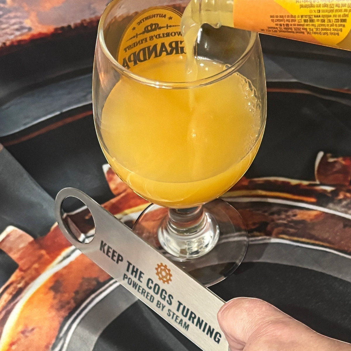Stainless Steel Bar Blade with Steampunk Cog with drink poured alongside bar blade