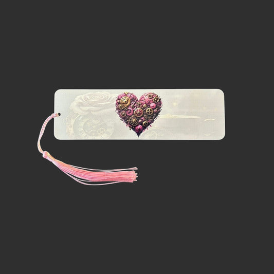 Horizontal view of an aluminium bookmark featuring an original pink steampunk heart illustration with intricate bronze clockwork detailing and a matching pink tassel.