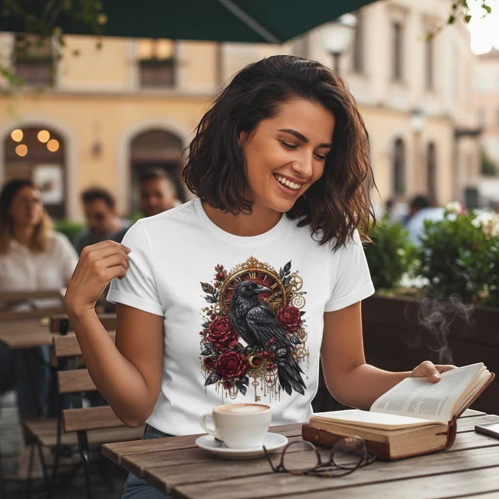 Woman reading a book outdoors with a white t-shirt featuring a black crow and red roses design.
