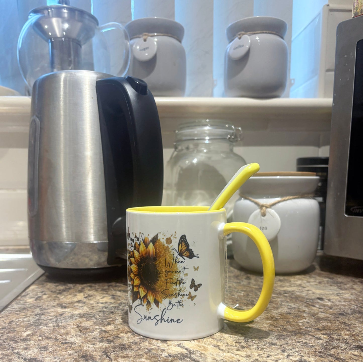Yellow handle and inner mug with be the sunshine design sat on kitchen table.