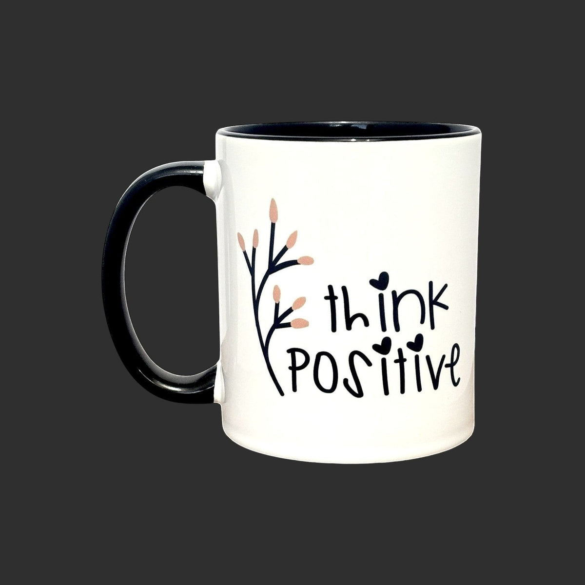 White ceramic mug with black handle and rim, featuring a floral branch and the text "think POSITIVE".
